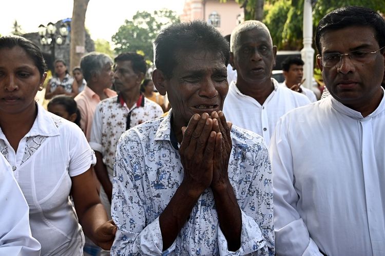 Seorang pria menangis sambil berjalan di belakang peti jenazah seorang korban bom Minggu Paskah usai misa di gereja St Sebastian, Negombo, Sri Lanka, Selasa (23/4/2019). 