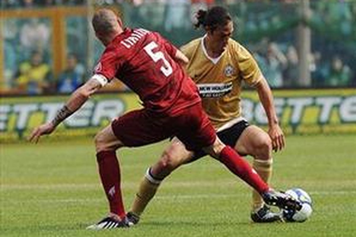 Pemain Reggina, Bruno Cirillo (kiri) mencoba mengadang gelandang Juventus, Mauro Camoranesi.