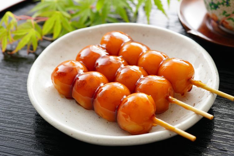 Ilustrasi mitarashi dango, wagashi alias dessert khas Jepang bertekstur kenyal seperti mochi dengan siraman sirup. 