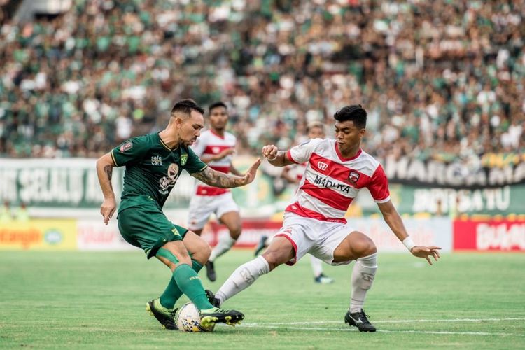 Pemain Persebaya Damian Lizio menekan pertahanan Madura United di pertandingan leg pertama semifinal Piala Presiden 2019 di Stadion Gelora Bung Tomo, Rabu (3/4/2019).