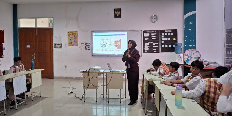 Rahayu Sulistyani yang merupakan seorang guru di Sekolah Dasar (SD) Bosowa Bina Insani, Bogor, Jawa Barat, terlihat sedang mengajar anak didiknya di kelas