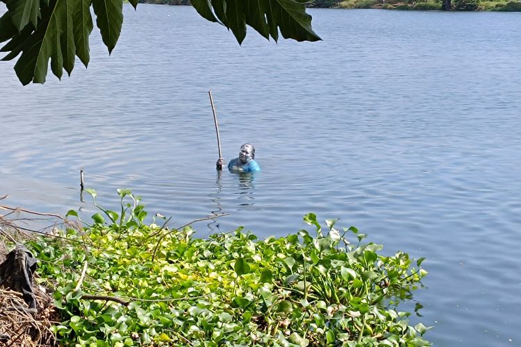 Manusia silver kedapatan menceburkan diri saat petugas melakukan razia penertiban di simpang perempatan lampu merah Jalan Raya Tri Dharma, Gresik, Jawa Timur.
