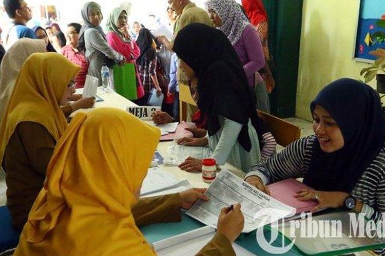 Calon siswa didampingi orangtua/wali murid mengantre saat pendaftaran Penerimaan Peserta Didik Baru (PPDB) Sekolah Menengah Pertama (SMP), di SMP Negeri 1 Medan, Selasa (2/7/2019). PPDB tahun ajaran 2019/2020 tingkat SMP di Kota Medan dibuka mulai hari ini, Selasa 2 Juli hingga Sabtu 6 Juli 2019. (M Daniel Effendi Siregar)
