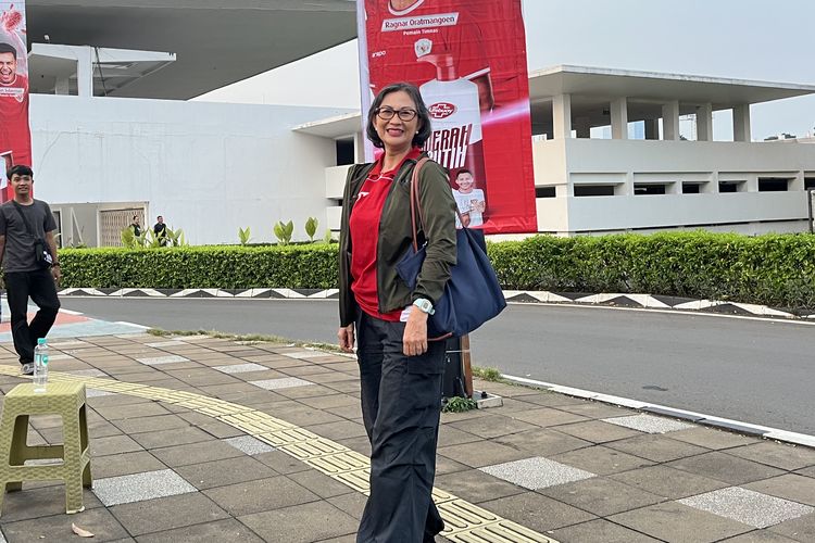 Puji, salah satu penonton pertandingan bola Indonesia vs China, mengenakan jersey dan jaket bomber army di Gelora Bung Karno, Jakarta Pusat, Kamis (5/6/2025).