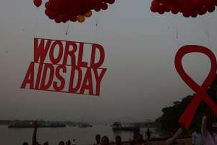 Aktivis sosial dan anak-anak melepaskan tanda simbolis kesadaran Hari AIDS Sedunia yang terikat dengan balon, di Kolkata, India, Rabu (30/11/2016).