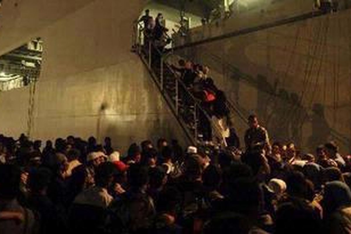 Penumpang asal Pulau Bawean yang tertahan di Pelabuhan Gresik, Kabupaten Gresik antre naik KRI Makasar di Pelabuhan Gresik, Senin (17/1/2011) malam. Sekitar 2.600 warga Bawean tersebut tertahan sejak Sabtu (8/1/2011) karena tiga kapal penumpang yang melayani pelayaran reguler Gresik-Bawean tidak berlayar akibat cuaca buruk.