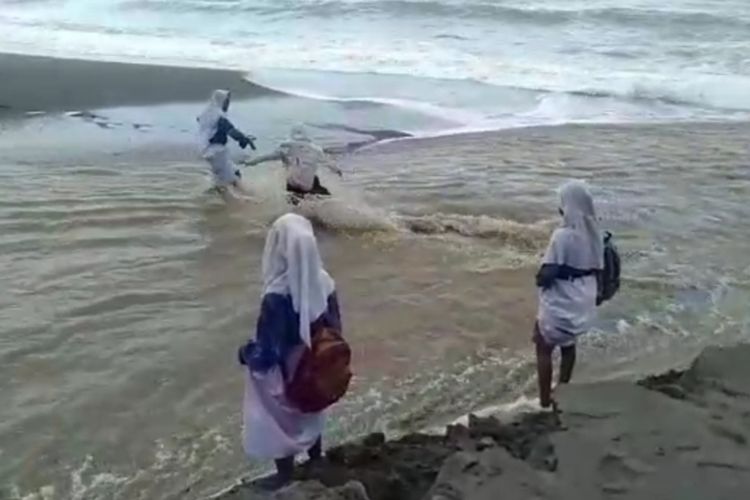 Sejumlah siswi SMP Negeri 16 Seram Bagian Timur, Maluku harus menyeberangi derasnya sungai saat pergi ke sekolah mereka di Desa Batuasa, Kecamatan Werinama, Kamis (16/7/2020)