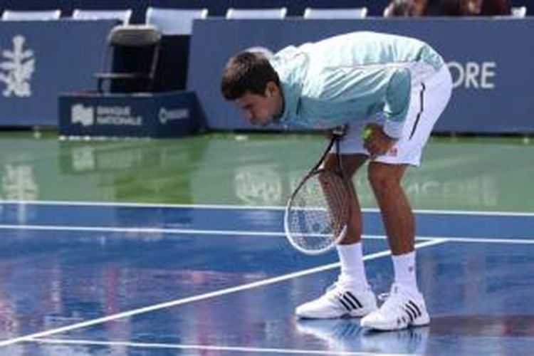 Petenis Serbia, Novak Djokovic tetap hadir di lapangan meski tak bisa menjalani sesi latihan karena hujan, jelang turnamen Masters 1000, Rogers Cup di Montreal, Senin (5/8/2013).