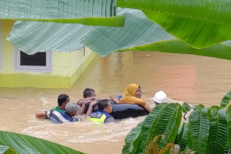 Anggota polantas Polsek Lirik, Bripka Donni Malindo bersama warg berenang mengevakuasi seorang nenek yang terjebak banjir di Desa Wonosari, Kecamatan Lirik, Kabupaten Indragiri Hulu, Riau, Kamis (1/6/2023).