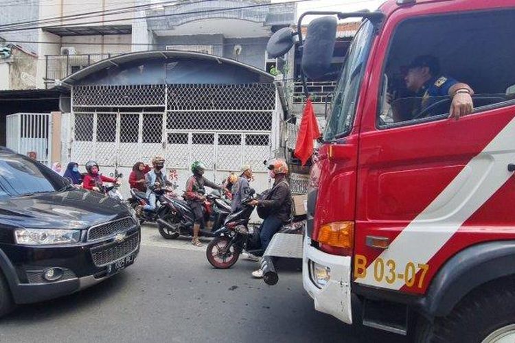 Mobil damkar kejebak macet di gang sempit lantaran terhalang mobil yang melaju di hadapannya pada Senin (1/8/2022). 