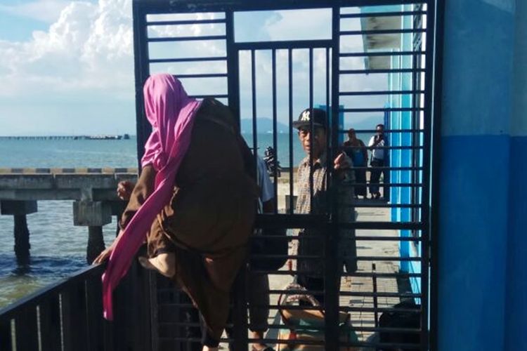 Seorang penumpang speed boat di Pelabuhan Sei Pancang, Sebatik, harus melompati pagar untuk keluar dari kawasan pelabuhan karena pengelola pelabuhan mengunci semua pintu.