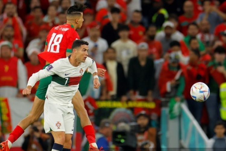Penyerang timnas Portugal Cristiano Ronaldo (kanan) berduel dengan bek Maroko Jawad El Yamiq pada laga perempat final Piala Dunia 2022 di Stadion Al Thumama, Doha, Qatar, Sabtu (10/12/2022) malam WIB.