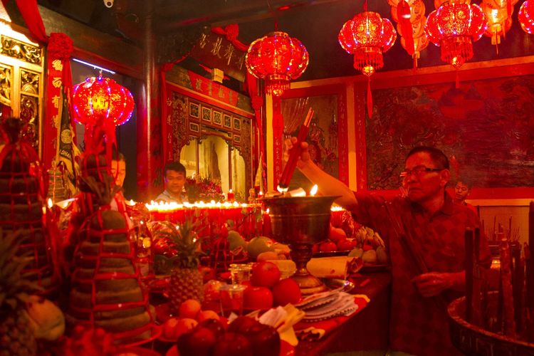 Sejumlah warga Tionghoa melakukan sembahyang di malam Imlek di Vihara Dhanagun, Kota Bogor, Jawa Barat, Jumat (24/1/2020). Usai memanjatkan doa warga Tionghoa menyalakan lilin yang disusun di halaman vihara.