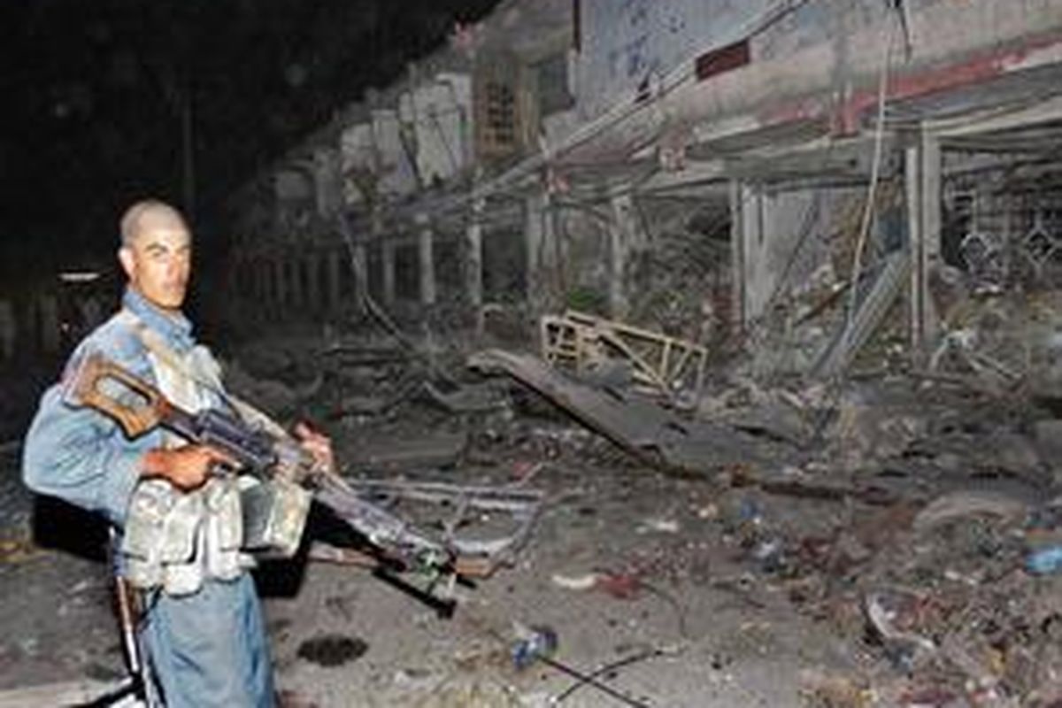 Aparat keamanan Afganistan berjaga di di lokasi ledakan bom truk dahsyat di Kandahar, 25 Agustus 2009.