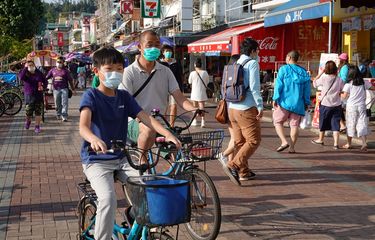 Warga Hong Kong terlihat memakai masker bepergian di pulau Cheung Chau saat libur Paskah, di tengah merebaknya virus corona. Foto diambil pada 12 April 2020.