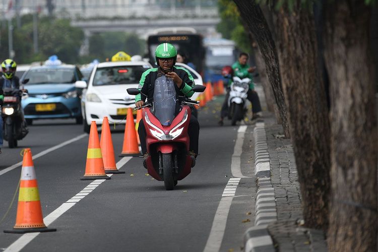 Ilustrasi menyalakan lampu motor pada siang hari.