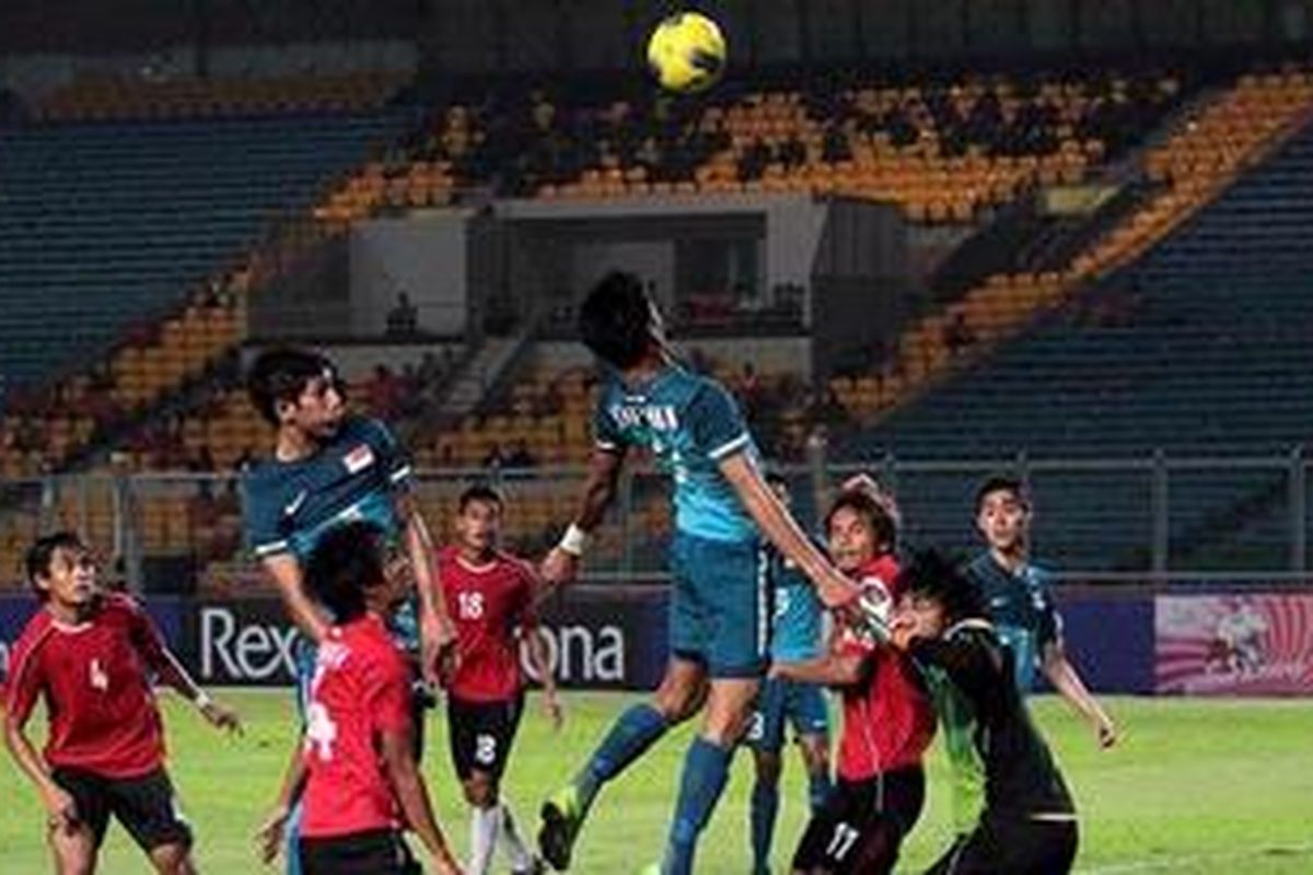 Pemain Timnas Singapura (kostum biru) berusaha menyundul bola ke arah gawang Kamboja saat pertandingan penyisihan SEA Games 26 di Stadion Gelora Bung Karno, Jakarta Pusat, Rabu (9/11/2011). Salah satu pemain Singapura melaporkan kondisi kesehatan mereka kepada Sekretariat Inasoc karena dugaan keracunan makanan.