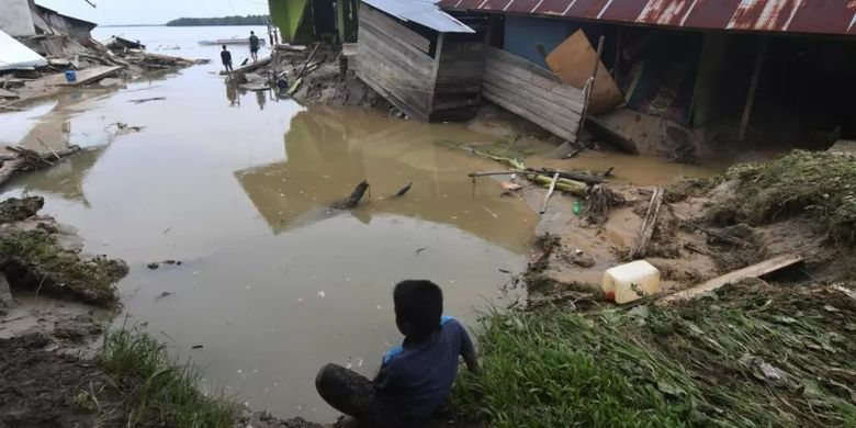 Warga berada di sekitar rumah yang rusak akibat diterjang banjir bandang di Desa Torue, Kabupaten Parigi Moutong, Sulawesi Tengah, Jumat (29/7/2022)