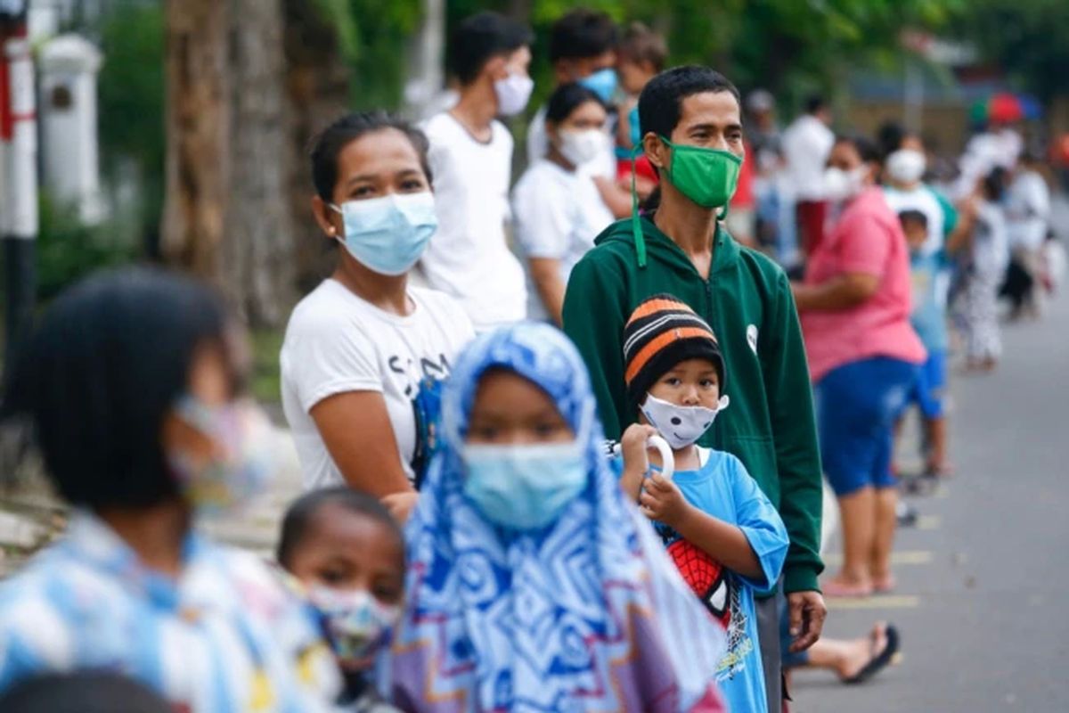 Orang-orang yang mengenakan masker pelindung antre untuk menerima makan gratis berbuka puasa selama bulan suci Ramadhan di tengah pandemi Covid-19 di Jakarta, 15 April 2021.