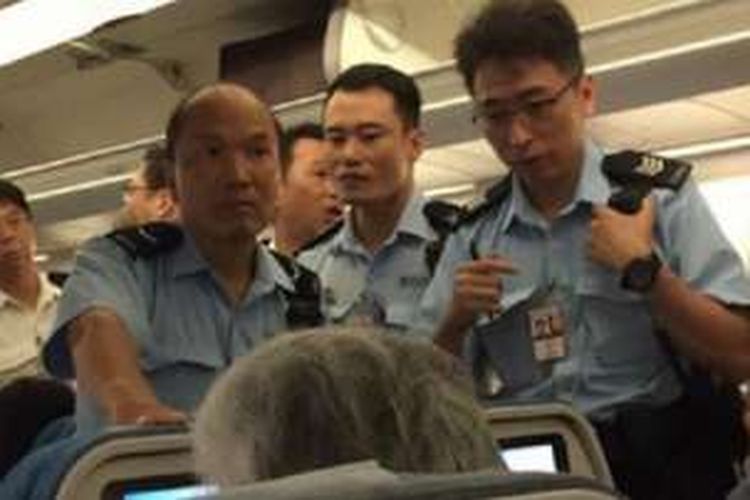 Sejumlah petugas naik ke dalam pesawat menyusul insiden penyiraman kepada pramugari oleh penumpang.