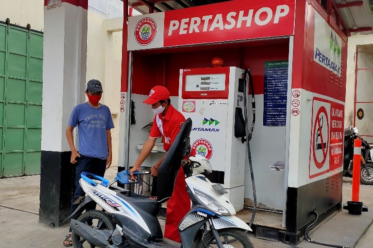 Petugas SPBU Mini atau Pertashop yang dikelola BUMDes melayani pengendara sepeda motor yang akan mengisi bahan bakar di jalan nasional Kabupaten Tegal, Senin (26/4/2021)