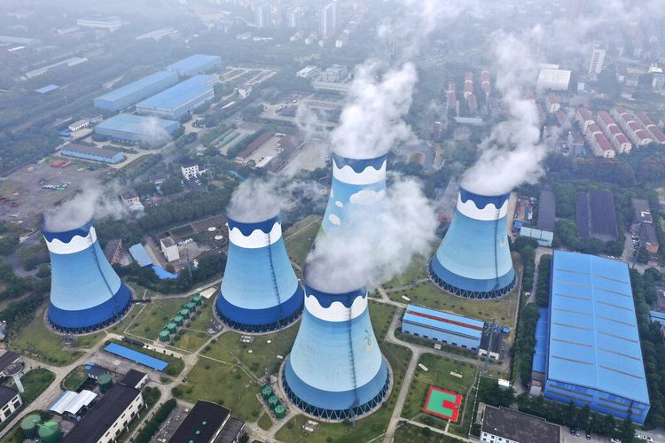 Uap mengepul keluar dari menara pendingin di pembangkit listrik tenaga uap (PLTU) batu bara di Nanjing di Provinsi Jiangsu, China pada Senin (27/9/2021). China dilanda krisis energi yang menyebabkan banyak pabrik tutup