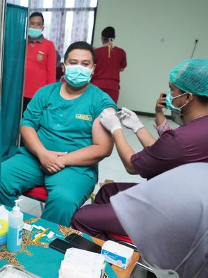 DIVAKSIN--Seorang nakes RSUD Kota Madiun mendapatkan vaksin booster kedua, Kamis (4/8/2022). Ratusan nakes yang bekerja di rumah sakit milik Pemkot Madiun mulai mendapatkan vaksin booster dosis kedua mulai hari ini. 
