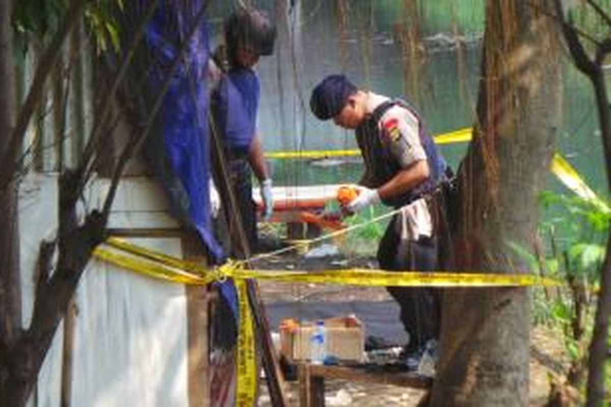 Petugas Gegana Polda Metro Jaya memeriksa benda yang diduga sebagai bahan peledak yang ditemuka di Kali Buaran, Duren Sawit, Jakarta Timur. Senin (2/6/2014).