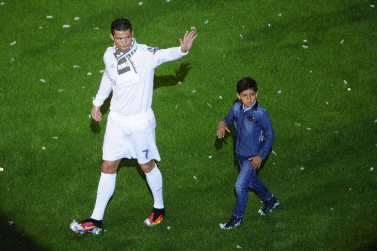 Cristiano Ronaldo membawa anaknya, Cristiano Ronaldo Jr, saat perayaan Real Madrid menjuarai final Liga Champions di Stadion Santiago Bernabeu, 29 Mei 2016.