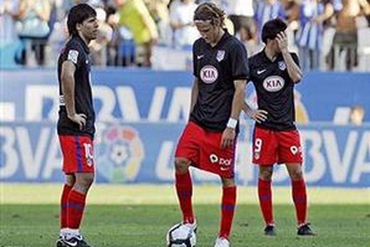 Pemain Atletico Madrid (ki-ka): Sergio Aguero, Diego Forlan, dan Jurado, tertunduk lesu ketika timnya dikalahkan Malaga pada laga perdana mereka di Liga Divisi Primera Spanyol, Minggu (30/8).