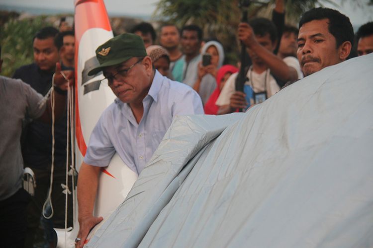 Gubernur Aceh Irwandi Yusuf di tengah kerumunan warga saat mengevakuasi pesawat pribadi miliknya jenis Shark Aero PK S121 yang mendarat darurat di bibir Pantai Desa Lam Awe, Kecamatan Peukan Bada, Kabupaten Aceh Besar, Sabtu (17/2/2018).