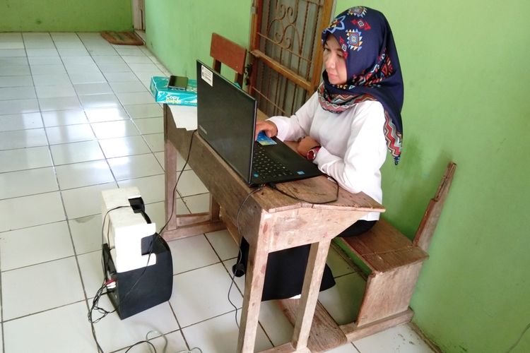 Salah seorang guru tengah duduk di bangku sekolah zaman Belanda di SDN Pisangsambo 1, Kecamatan Tirtajaya, Kabupaten Karawang, Rabu (7/11/2019).