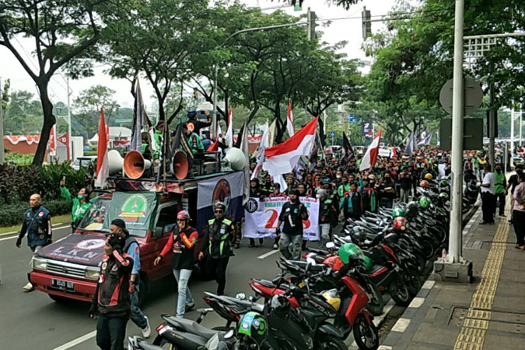 Sejumlah ojek online (Ojol) melakukan longmarch untuk melaksanakan aksi demonstrasi di depan Gedung DPR/MPR RI, Jakarta Pusat, Senin (29/8/2022).