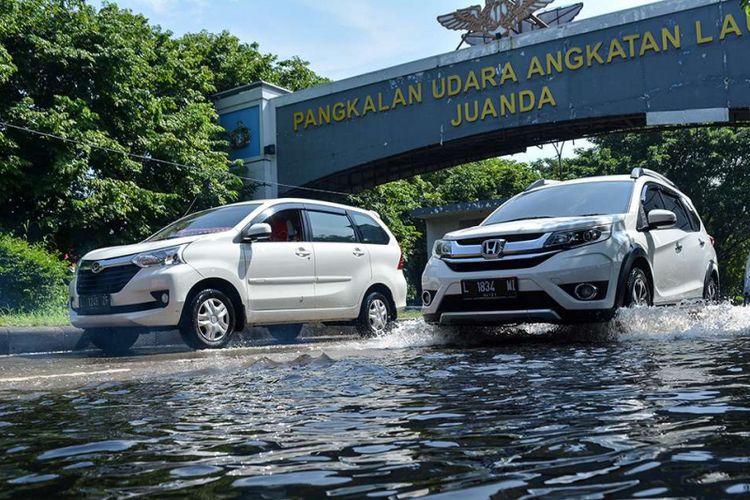 Kendaraan menerobos banjir di Jalan Raya Juanda, Sidoarjo, Jawa Timur, Senin (21/1/2019). Hujan yang turun dengan intensitas cukup tinggi sejak Minggu (20/1/2019) sore menyebabkan aktivitas transportasi di kawasan bandara juanda tergenang banjir dengan ketinggian 30-50 cm.