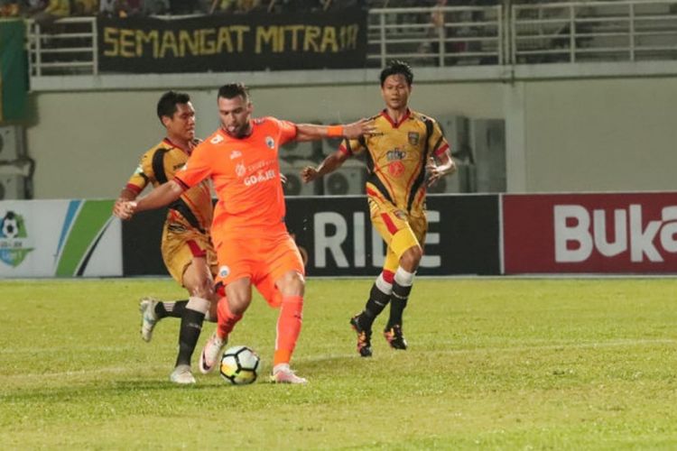 Penyerang Persija Jakarta Marko Simic dijaga ketat pemain Mitra Kukar di Stadion Aji Imbut, Tenggarong, Sabtu (21/7/2018).

