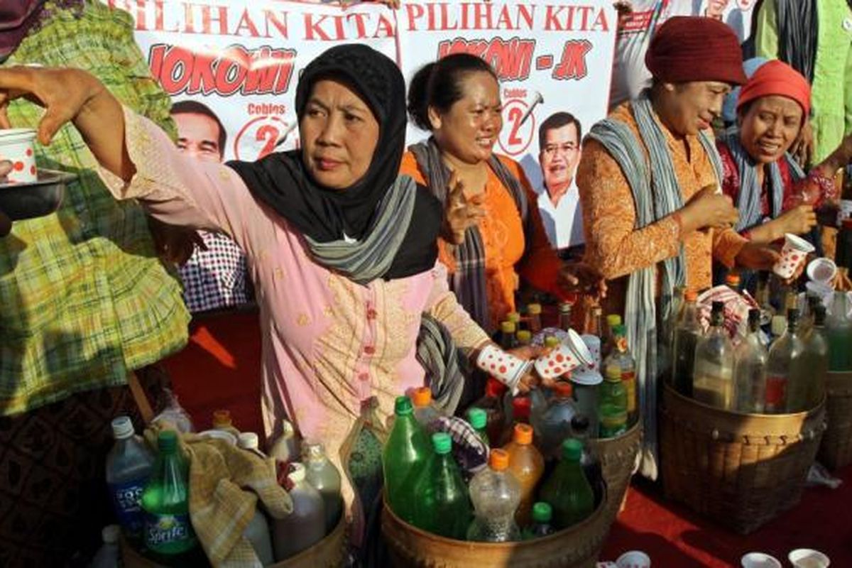 Penjual jamu gendong memberikan jamu gratis kepada warga yang sedang menikmati car free day di sekitar bundaran HI Jakarta Pusat, Minggu (8/6/2014). Penjual jamu ini memberikan jamu gratis sebagai ungkapan dukungannya kepada pasangan Jokowi-JK.