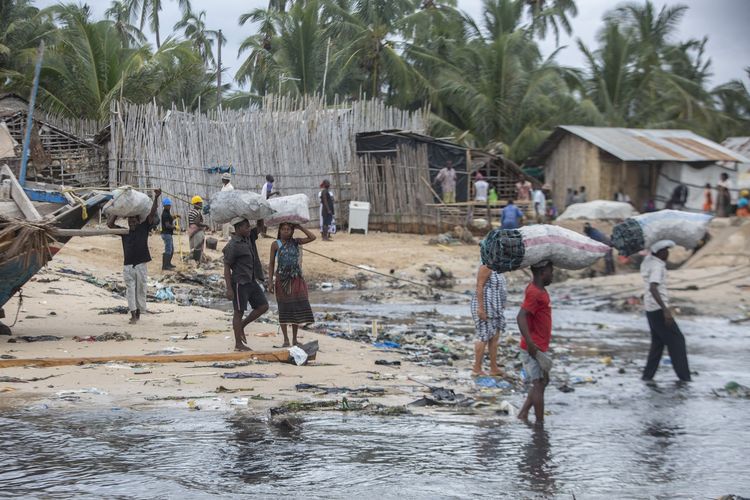 Orang-orang membawa karung di permukiman Paquitequete, untuk menunggu kapal datang mengangkut warga kota Palma dan Afungi, yang kotanya diserang ISIS pada 30 Maret 2021.