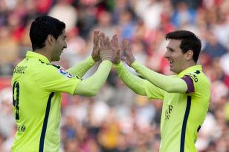 Penyerang Barcelona Lionel Messi (kanan) merayakan dengan rekan timnya Luis Suarez keberhasilan mencetak gol ke gawang Granada, pada pertandingan Primera Division, di Los Carmenes, Granada, Sabtu (28/2/2015). Laga itu berakhir 3-1 untuk Barcelona. 