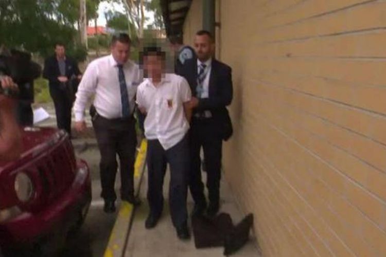 Polisi menggiring pelaku penusukan di Bonnyrigg High School, Sydney, Kamis (2/2/2017). 