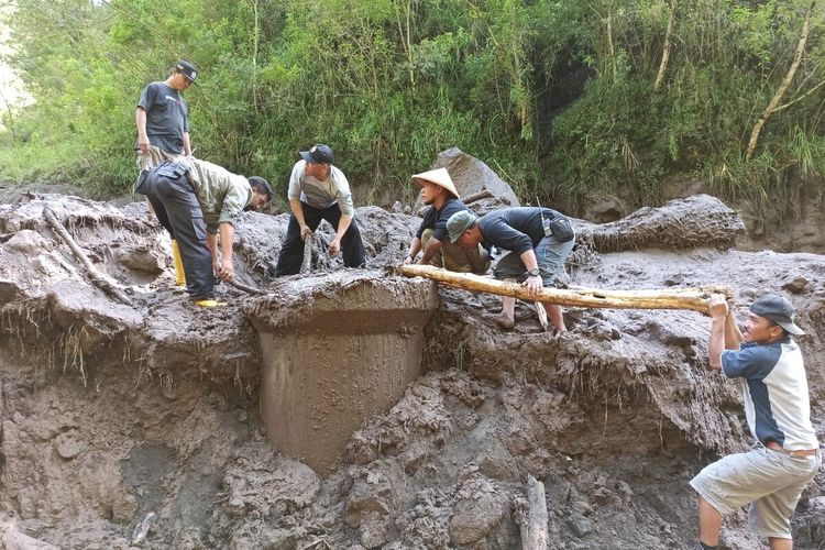 Warga melakukan perbaikan jaringan pipa induk di Kali Bebeng yang rusak parah setelah diterjang banjir lahar dingin Gunung Merapi.