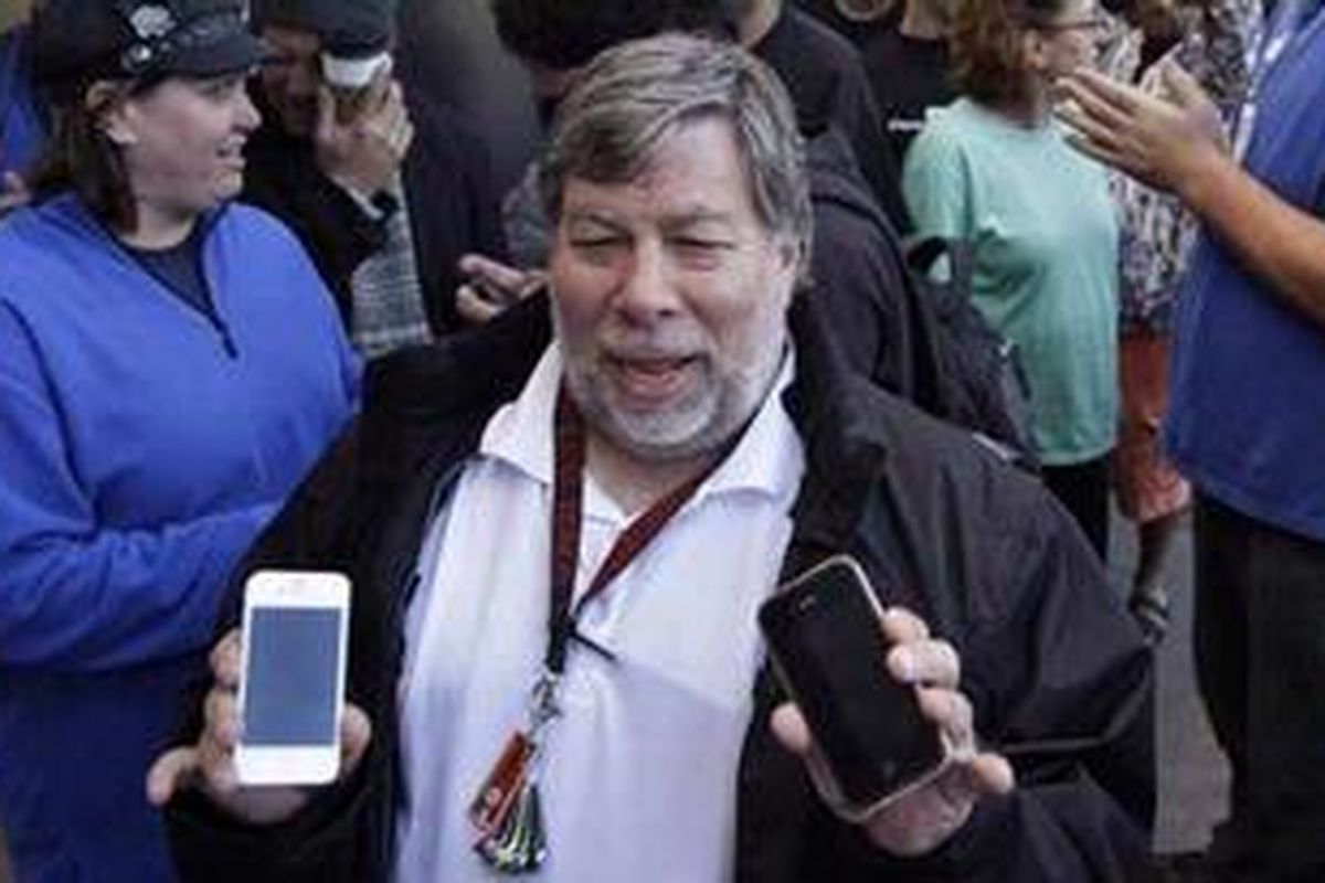 Steve Wozniak, tampak sedang memegang iPhone versi warna putih dan hitam. Wozniak turut andil mendirikan Apple bersama Steve Jobs.
