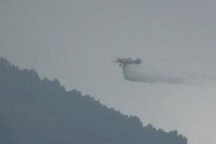 Pesawat udara menyiramkan air ke titik api di Lereng Gunung Merbabu, Kamis (8/10/2015)