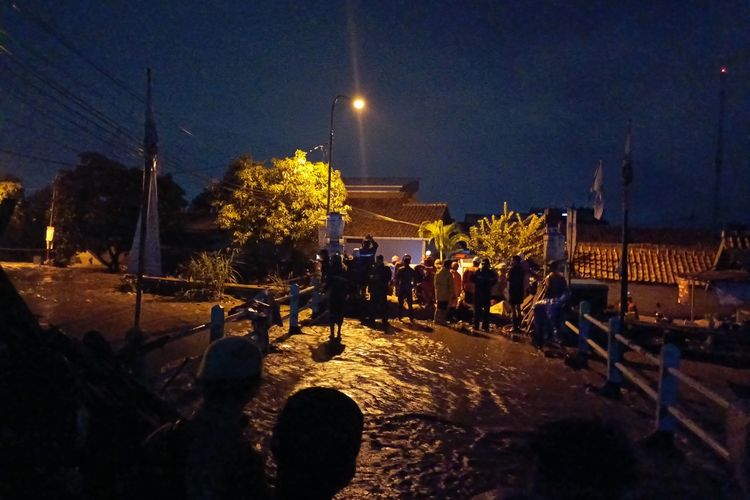 Sejumlah petugas dari Tim SAR tengah melakukan proses evakuasi warga Kampung Lamajang Peuntas, Desa Citeureup, Kecamatan Dayeuhkolot, Kabupaten Bandung, Jawa Barat yang terdampak tanggul jebol pada Kamis (11/1/2024)