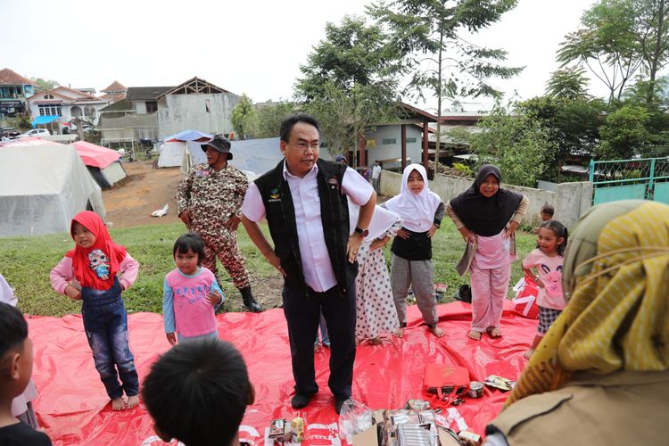 Sekretaris Jenderal (Sekjen) Kemensos selaku Pelaksana Tugas (Plt) Direktur Jenderal (Dirjen) Perlindungan dan Jaminan Sosial (Linjamsos) Harry Hikmat saat bermain dengan anak-anak terdampak gempa Cianjur.