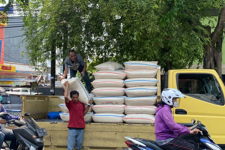 Seorang pria tengah memikik beras seberat 50 kilogram yang diturunkan dari truk di Pasar Rawa Badak, Koja, Jakarta Utara, Rabu (11/10/2023).