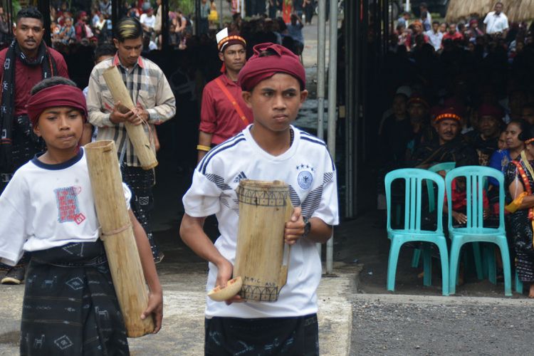 Kaum laki-laki Ngada ditugaskan untuk menyuguhkan tuak atau moke lokal untuk menggantikan minuman air setelah makan uwi (ubi) saat ritual Reba Ngada dilaksanakan di Kampung Langa, Kecamatan Bajawa, Kabupaten Ngada, Flores, NTT, Selasa (15/1/2019). 