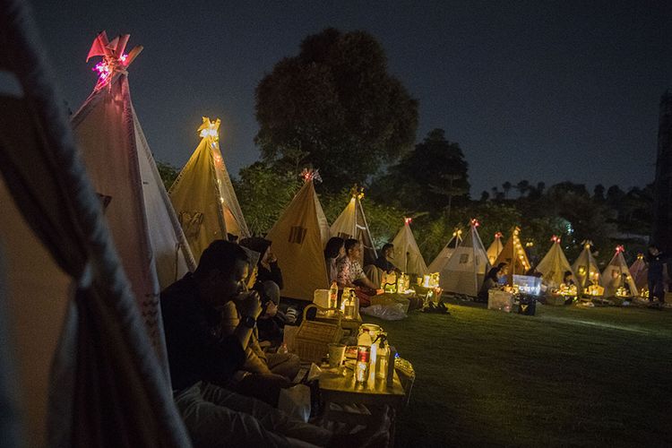 Pengunjung berada di dalam tenda saat menyaksikan film di bioskop outdoor 'Tenda di Bawah Bintang' di Parongpong, Kabupaten Bandung Barat, Jawa Barat, Rabu (4/11/2020). Bioskop outdoor Tenda di Bawah Bintang dihadirkan untuk memenuhi keinginan masyarakat yang ingin menyaksikan pertunjukan film layar lebar dengan tetap menerapkan protokol kesehatan dan social distancing.