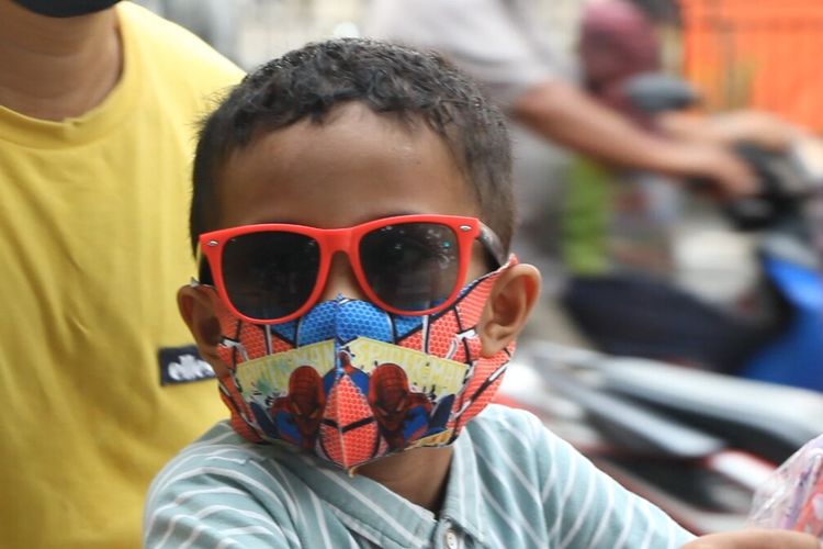 Seorang anak di Mataram, NTB mengenakan masker anak bergambar spiderman. Anak anak kerap enggan mengenakan masker karena tak sesuai dengan ukuran usia mereka. Masker anak sangat dibutuhkan karena anak anak sangat rentan tertular covid19