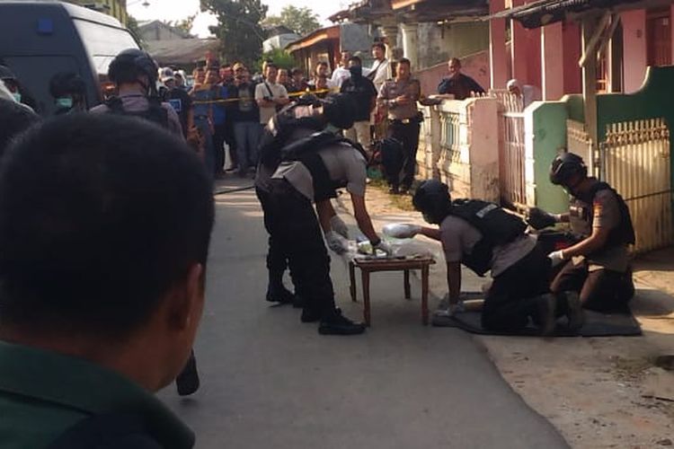 Tim Gegana Brimob Polda Lampung meletakkan sejumlah bahan yang diduga material pembuat bom di sebuah meja di depan rumah nenek dari terduga R di Way Halim, Selasa (15/10/2019) petang. Penggeledahan ini dilakukan karena Tim Densus 88 menemukan material bahan pembuat bom saat menangkap R di Telukbetung pada Senin (14/10/2019) kemarin.