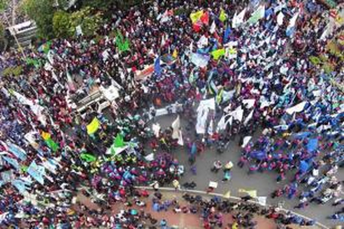 Ribuan buruh melakukan aksi unjuk rasa di Bundaran Patung Kuda, Jalan MH Thamrin, Jakarta, Selasa (1/9/2015). Mereka menuntut pemerintah menurunkan harga sembako, menolak PHK akibat rupiah melemah dan perlambatan ekonomi.